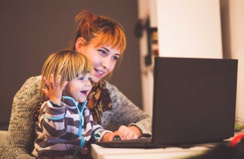 Mutter und Kind schauen zusammen auf dem Bildschirm eines Laptops